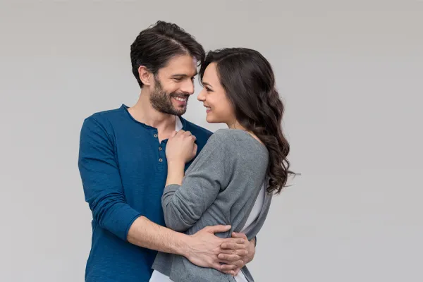 Erectile-Dysfunction-Doctor A man in a blue shirt embracing a woman in a gray shirt smiles due to his successful erectile dysfunction care from Proactive Wellness Centers in Loudoun County.