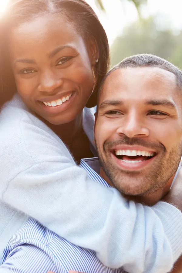 Erectile-Dysfunction-Treatment A woman riding on a man's back, both smiling due to help with erectile dysfunction from Proactive Wellness Centers in Loudoun County.