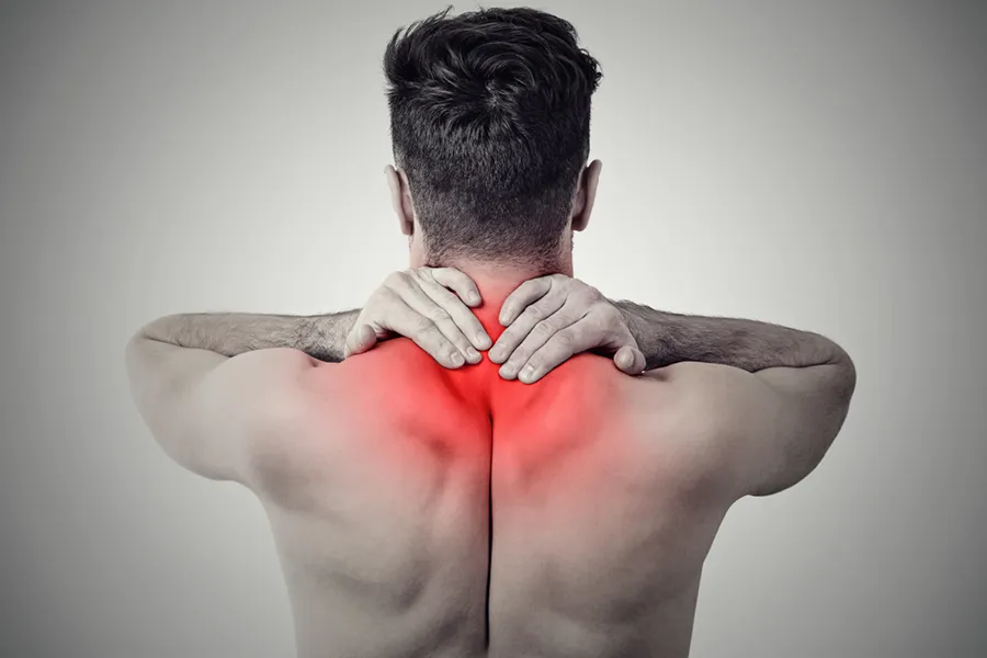 Fibromyalgia-Doctor An image from behind of a man suffering from Fibromyalgia rubbing an area illustrated red with pain in his shoulders and neck . Get fibromyalgia treatment from Proactive Wellness Centers in Loudoun County.