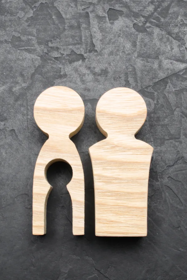 Infertility-Treatment Woodcut figures of a man and woman with a child-shaped area cut out from the woman figure. Get treatment for infertility from Proactive Wellness Centers in Loudoun County.