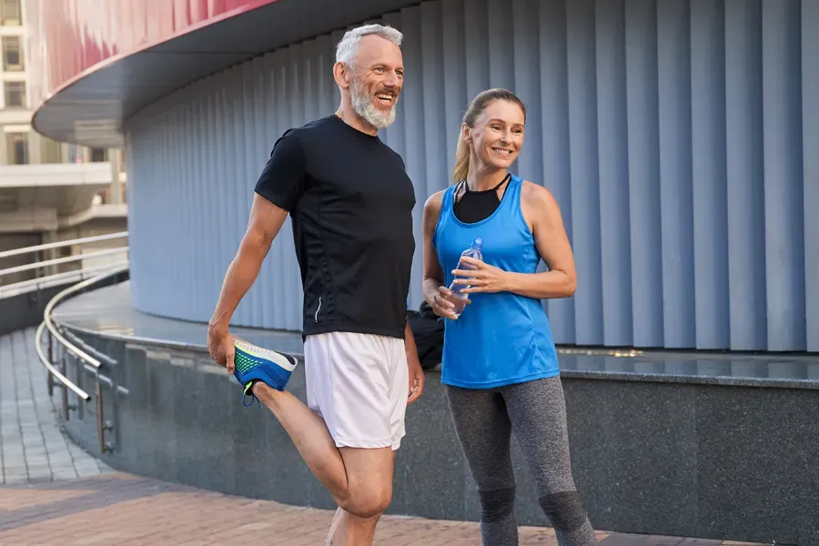 Peptides-for-Healing-and-Recovery-Doctor A middle-aged couple happily stretch and prepare for exercise after receiving effective peptide therapy for healing and recovery from Proactive Wellness Centers in Loudoun County.