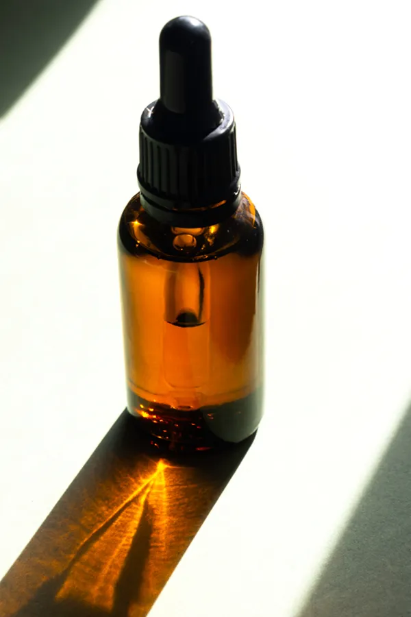 Performance-Enhancing-Peptides-Treatment A brown dropper bottle on a table lit by sunlight, representing performance enhancing peptide treatment from Proactive Wellness Centers in Loudoun County.
