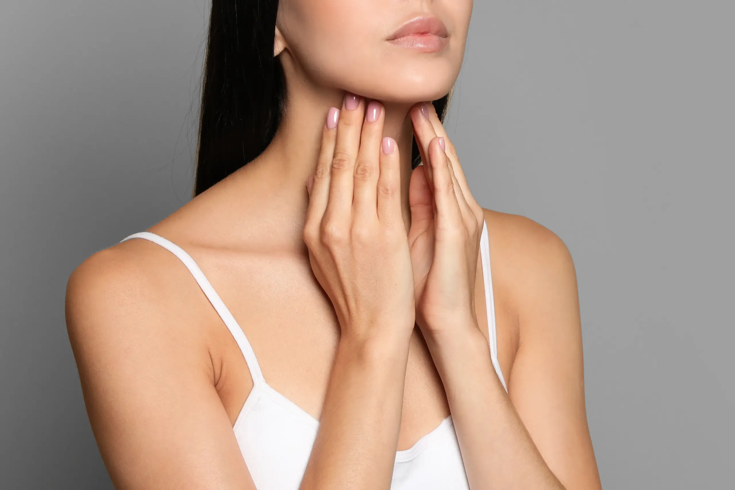 Thyroid-Doctor A woman in a white tank top touches her neck looking for signs of thyroid disorder. Get help for thyroid disorders from Proactive Wellness Centers in Loudoun County.